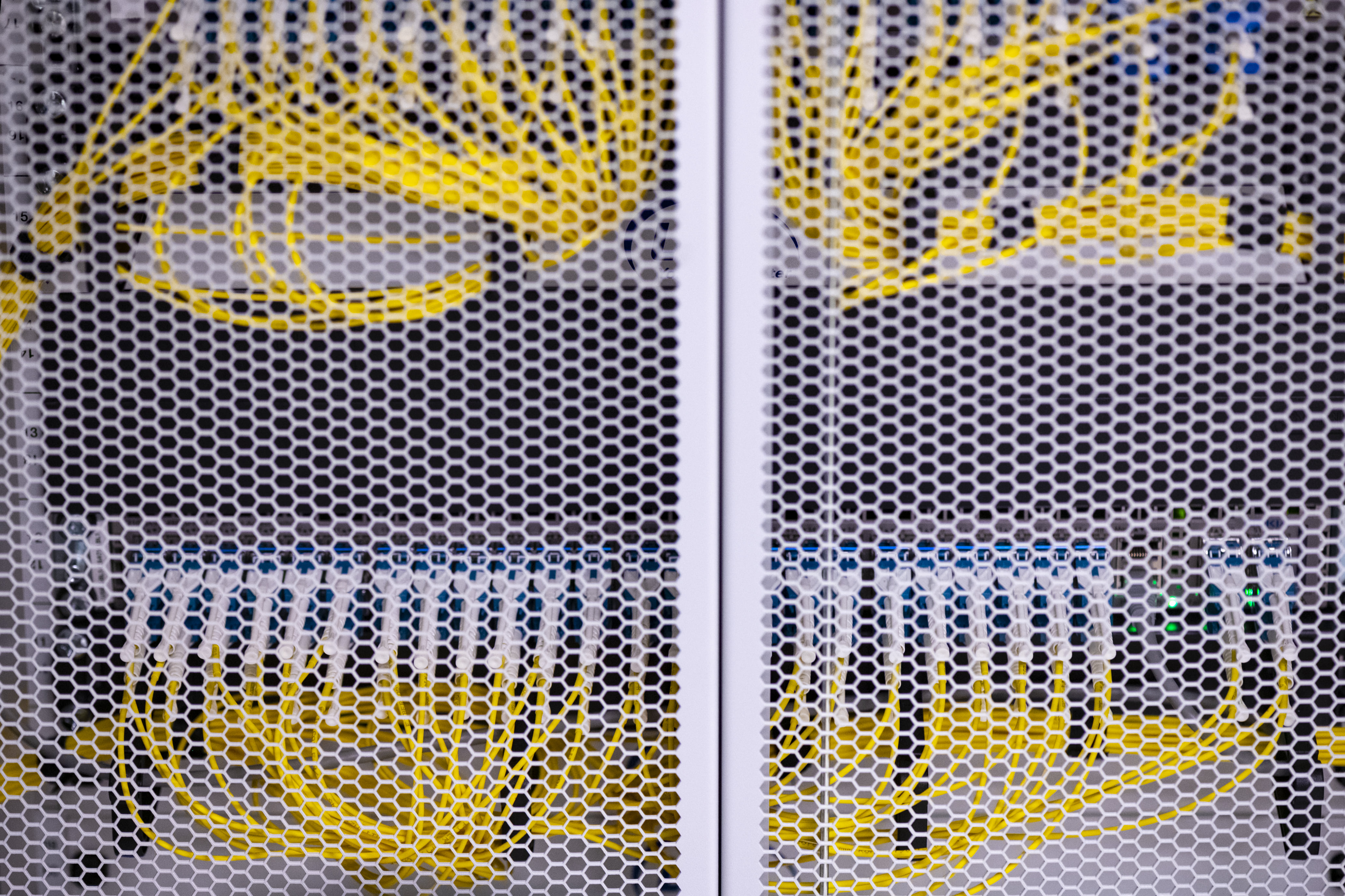 Gele kabels voor connectiviteit achter een wit raster