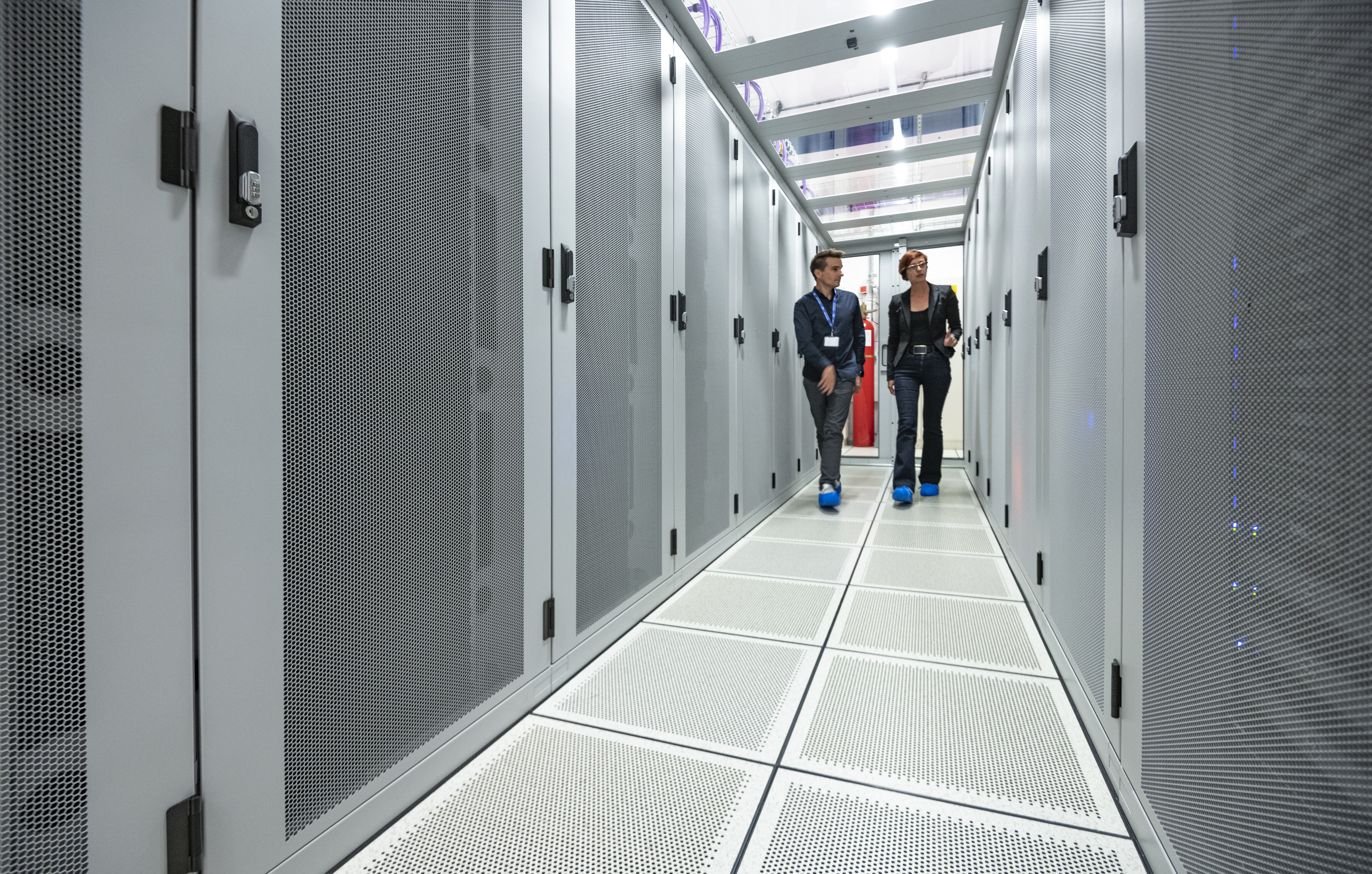 Twee werknemers in de cold corridors met geperforeerde tegels in datacenter